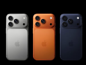 Three iPhones in silver, orange, and black with triple cameras.
