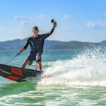 A person enjoying hydrofoiling on a sunny day with splashing water.