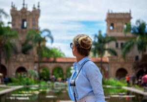 Woman enjoying a scenic view at a historic garden with fountains.