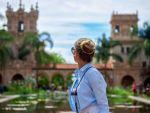 Woman enjoying a scenic view at a historic garden with fountains.