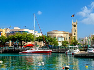 Sailboats docked near historic buildings under a clear blue sky.