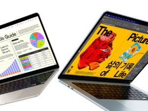 Two laptops displaying different content, one with a chart and the other with a colorful magazine cover.